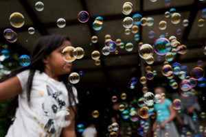 Girl behind bubbles , playing outdoor
